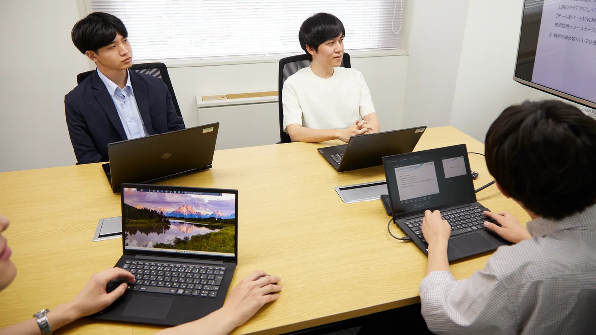 システム構成を確認しながら議論するエンジニアチーム