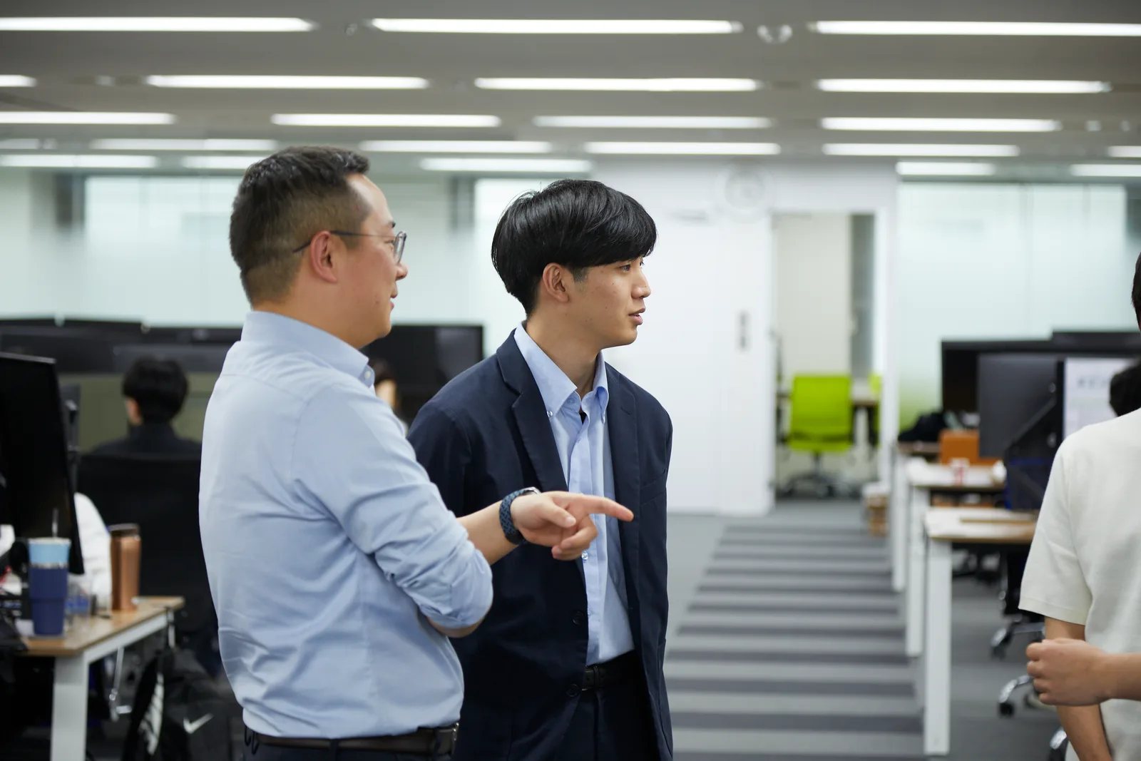 オフィスで先輩社員が後輩に相談しながら進めるベストスキップの現場